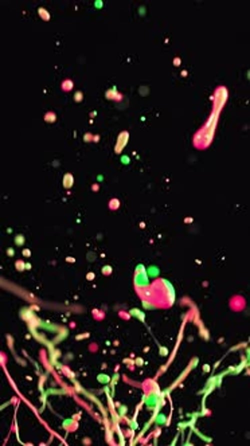 Splashing Neon Pink And Green Paint Particles In Slow Motion