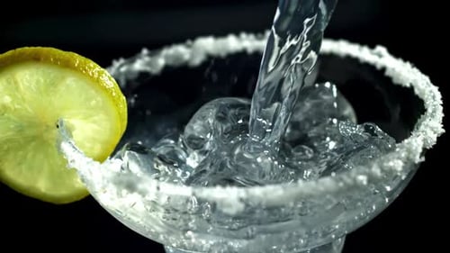 Clear Liquid Pours into Glass with Lemon and Salt