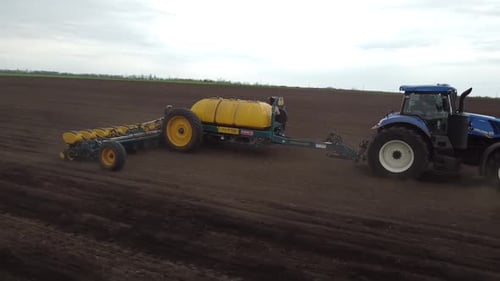 Blue tractor OA working on the field in Ukraine