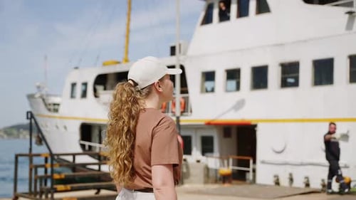 Woman Walks to Ferry Ready to Board on Sunny Day Casual Attire Enjoys Seaside Approaches Ship at
