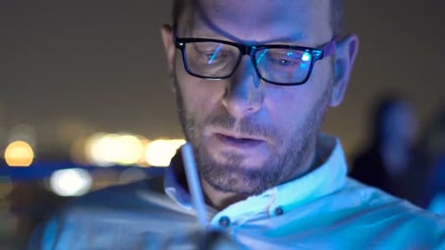 Sad, Unhappy Man Drinking Cocktail Sitting On Terrace In Bar At Night