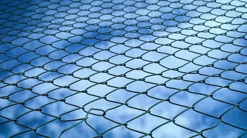 Chain Link Fence against the Cloudy Blue Sky