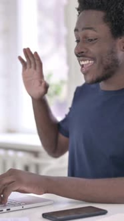 Young Man Video Calling on Laptop at Home