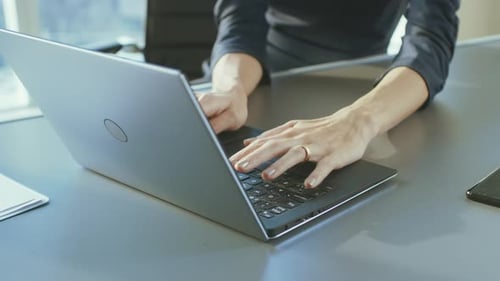 Close-up On the Hands of a Businesswoman Typing on a Laptop Keyboard. Female Using Laptop in the Of