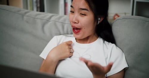 Woman Smiling and Talking on a Laptop at Home