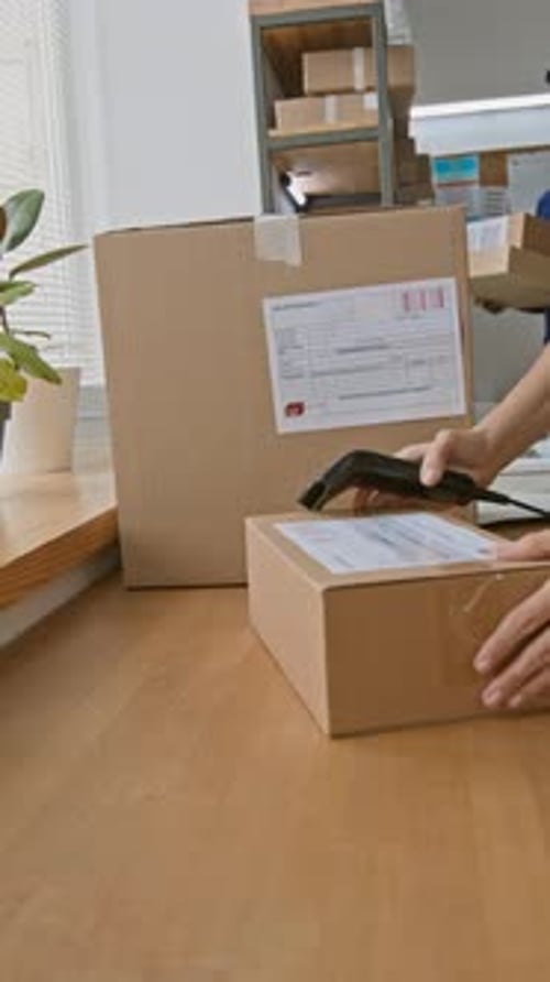 Unrecognizable Employees Processing Parcels at Online Retail Delivery Outlet