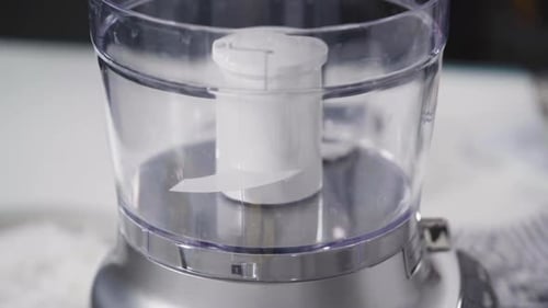 Mischen von Zutaten in einer Küchenmaschine, um hausgemachte Kokosnusskekse zuzubereiten