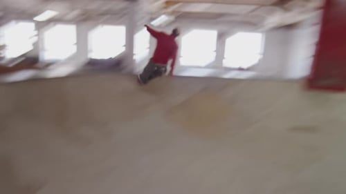 Man Skating Up and Down Bowl at Indoor Skatepark