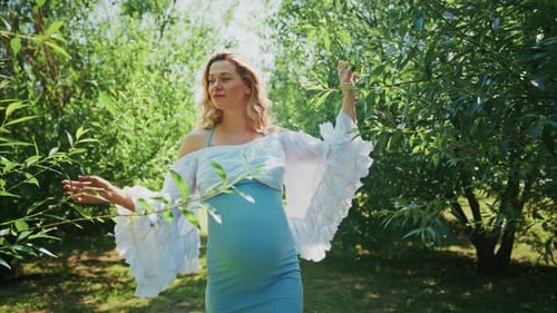 Expecting Mother Exploring a Sunny Orchard and Enjoying Nature's Beauty