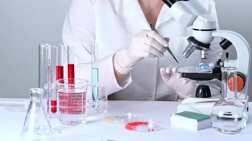 Wissenschaftler, der in einem biotechnologischen Labor mit Mikroskop arbeitet.