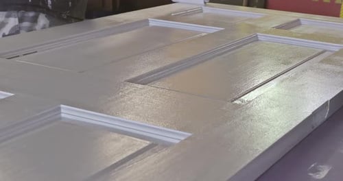 The New Door is Being Painted with White Paint Using a Roller to Apply the Paint