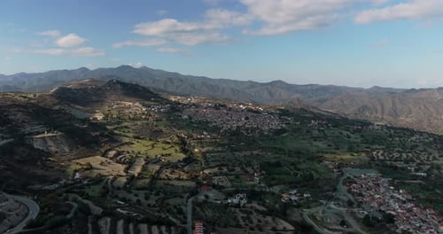 Wide aerial drone view of Lefkara village surrounded by mountain landscape and rural countryside in