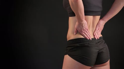 Fit Woman Soothing Her Back to Alleviate Muscle Tension