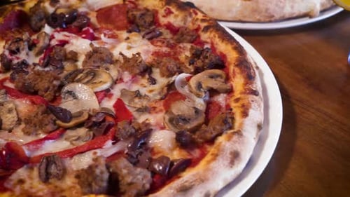 Handgemachte Pizza im neapolitanischen Stil, belegt mit Champignons, Wurst, roter Paprika, Slider-Nahaufnahme 4K