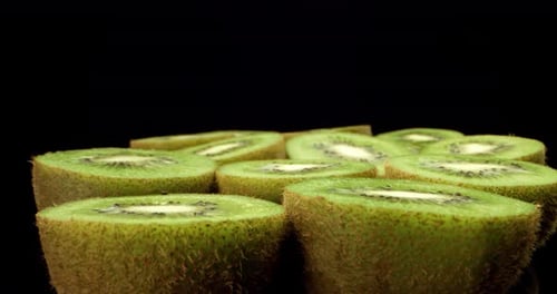 Juicy fresh kiwi fruit HQ cut in half super close up shoot fly over 4k shoot on dark background