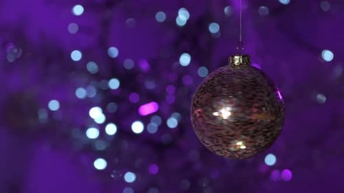 Christmas tree decoration. Christmas ball on bokeh background of flashing lights