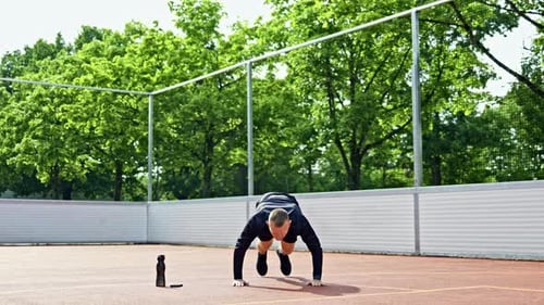 Man Exercising on Court Doing Burpees
