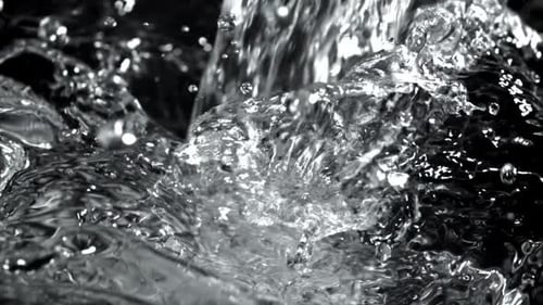 Water pouring on black background in a close up