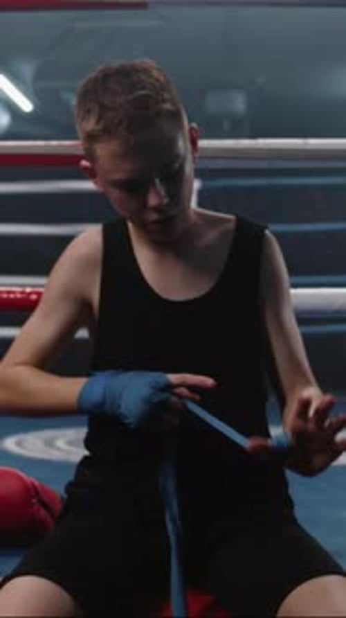 Young Boxer Wraps His Hands with Bandage for Martial Arts