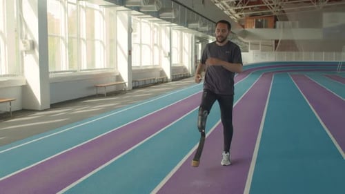 Man with Prosthetic Leg Warms up on Track