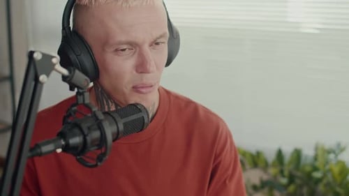 Journalist Speaking into Microphone while Recording in Studio