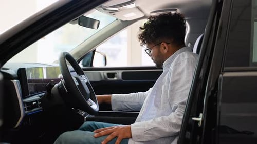 Arab Customer Testing New Car Features in Dealership