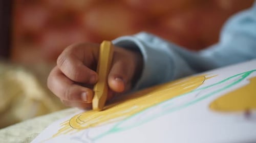 Kind zeichnet ein farbenfrohes Bild mit Fokus auf Kreativität