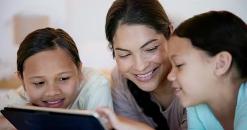 Woman and Children Using Tablet Device Together Indoors