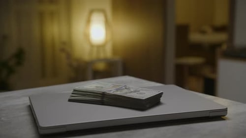 Stack of Money on Laptop Computer at Home