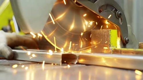 Engineer Cutting Metal Profile with Precision Saw in Manufacturing Facility