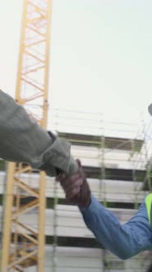 Construction Workers Shaking Hands at Construction Site