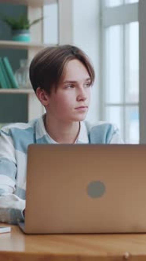 Young Adult Typing at Laptop in Home Office