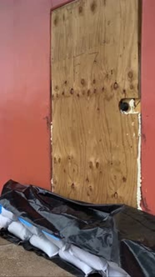 Boarded up businesses preparing for hurricane surge and flooding, sandbags