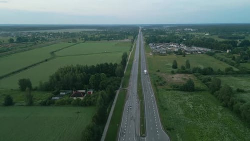 Aerial View of a Countryside Road Winding Through Lush Fields Creating a Tranquil Rural Landscape