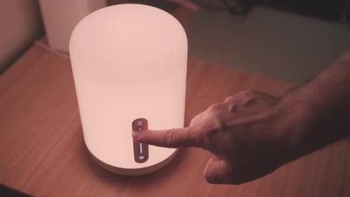 Hand Changes Colors on Modern Bedside Lamp