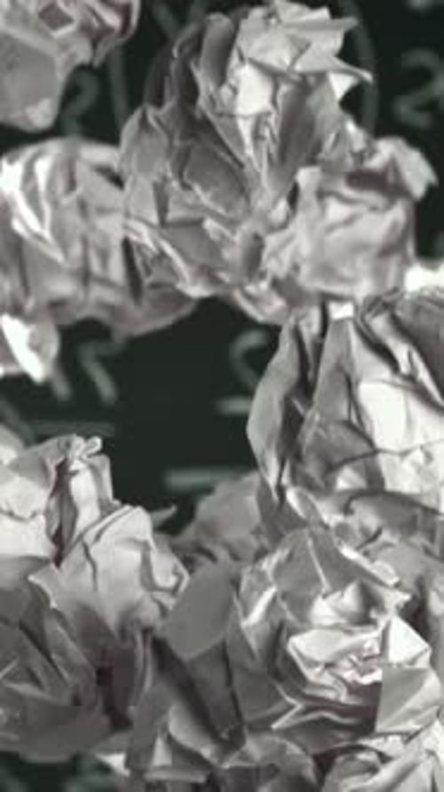 Crumpled Paper Rises and Falls Against the Background of the Blackboard Filmed on a Highspeed Camera