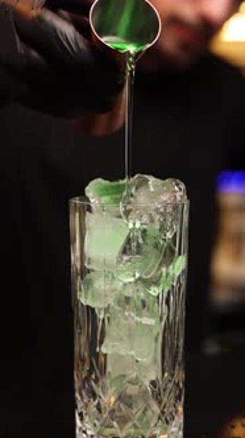 the bartender at the bar prepares alcoholic cocktails