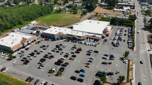 Orbiting aerial view of a shopping area with multiple storefronts on Whidbey Island.