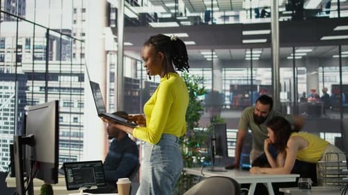 IT Staff Member Using Laptop to Do Programming in Office
