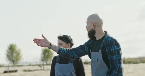 Bearded Man Talking and Hugging Happy Woman During Work on Farm in Countryside