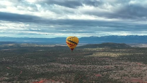 Yellow Hot Air Balloon Soaring High Over Forest State Park In Sedona, Arizona During Sunrise. Aerial