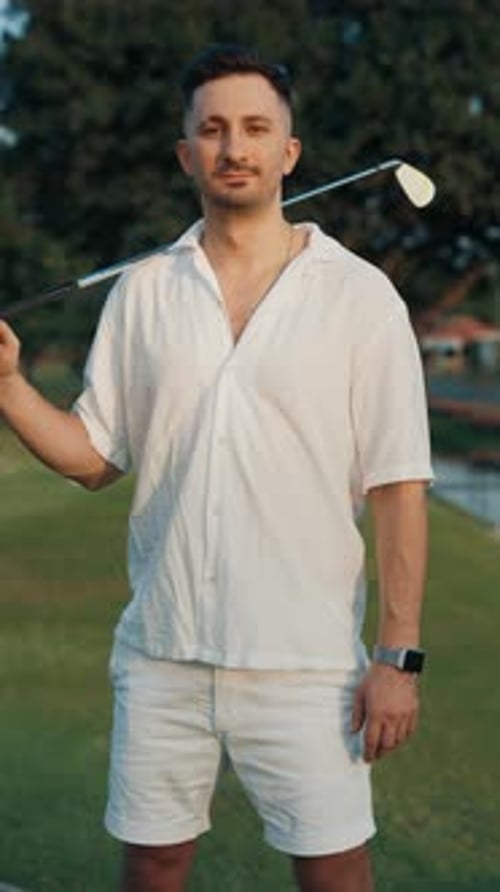 Male Golfer with Driver Looking at Camera on Golf Course