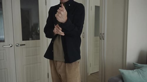 Young Adult Rolling Sleeves in an Interior Setting