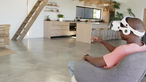 Using VR headset, man in modern kitchen, interacting with virtual environment, copy space