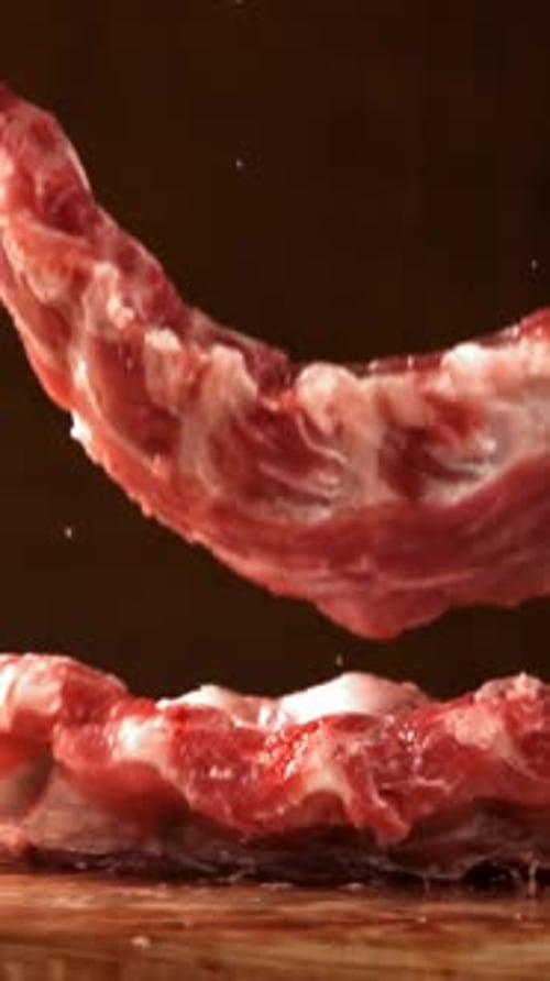 Raw Pork Ribs Fall Onto a Cutting Board Filmed on a Highspeed Camera at 1000 Fps