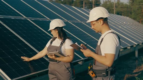 Engineers Inspecting Solar Panels in a Rural Setting