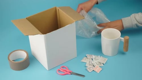 Mujer latina envolviendo una taza blanca en plástico de burbujas, ventas en línea, compras en línea y entrega al cliente