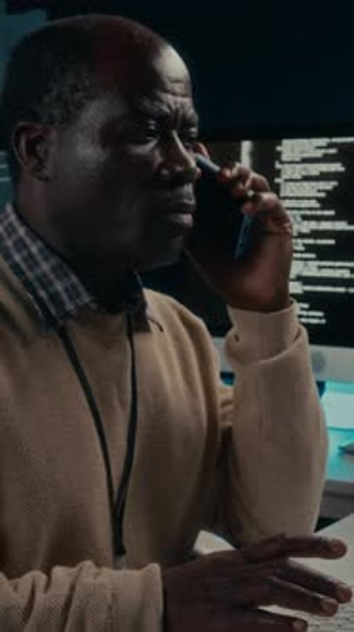 Man Working at Computer and Talking on Phone