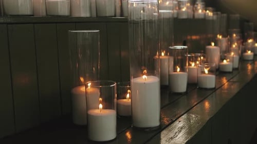 Illuminated Candles in Glass Vases on Wood Surface