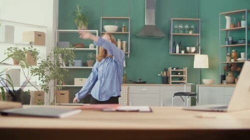Woman Dancing Energetically in a Modern Kitchen